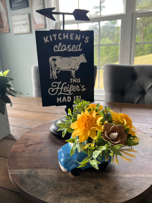 blue truck with yellow  wood flowers